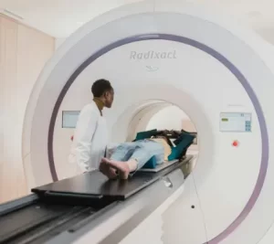 Paciente sometiéndose a una tomografía con la asistencia de un técnico médico